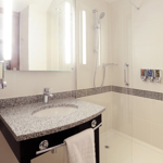 Modern hotel bathroom with shower, sink, and mirror at Hampton by Hilton Sheffield.
