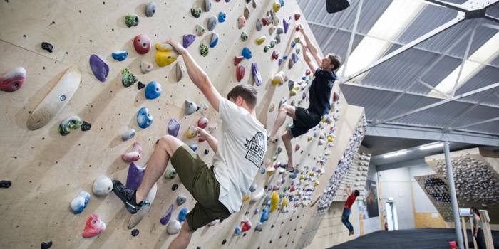 Two people on a climbing wall at Depot Climbing.