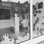The window at Cupola Gallery filled with white sculptures.
