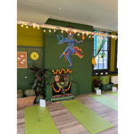 A room at the Green Light Sanctuary, with green walls, a wooden floor and yoga mats laid out in rows.