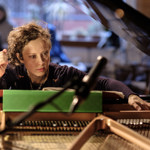 Xenia Pestova Bennett seated at a grand piano.