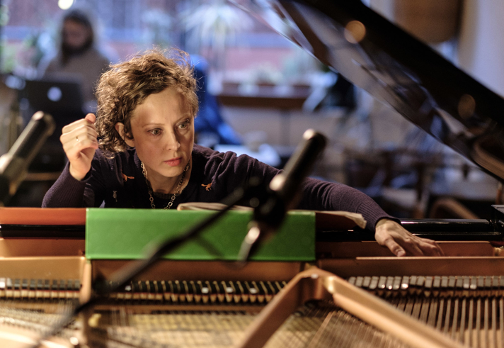 Xenia Pestova Bennett seated at a grand piano.