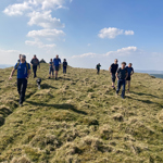 A group of people walking across open moorland. 