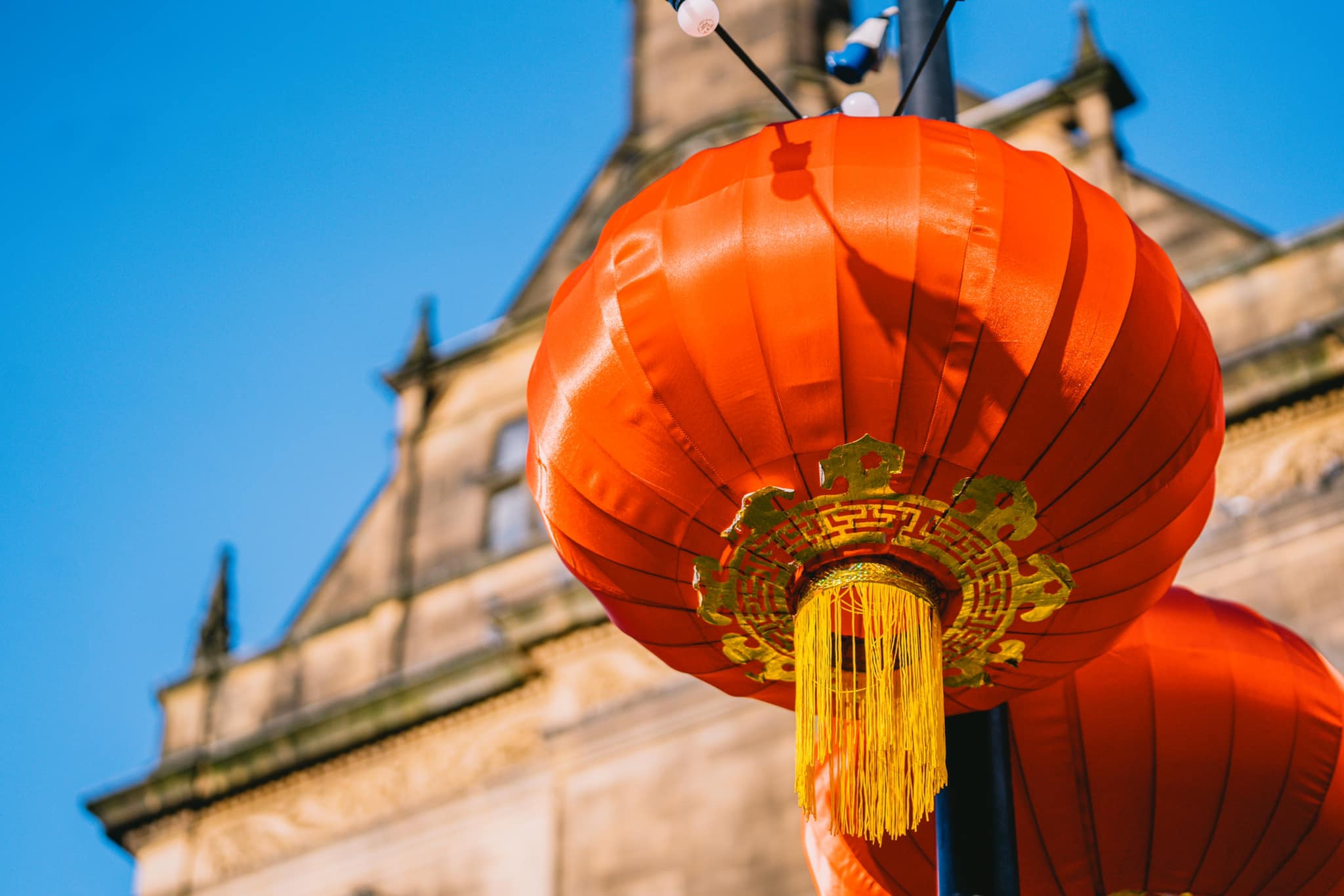 A close up of red lantern hung outside a historic building 