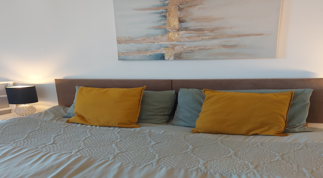 Double bed with soft coloured cushions