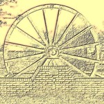 A wheel from a pit head set into a low wall.