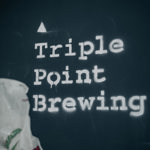 Triple Point Brewery logo in white type-font on black wall.