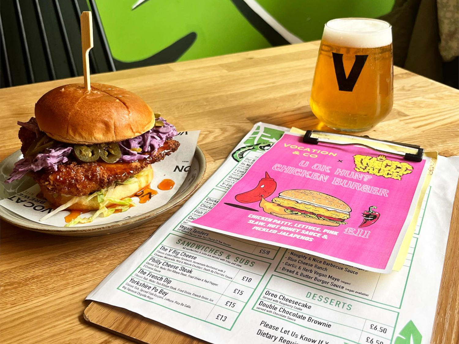 A burger and a glass of beer on a table at Vocation & Co