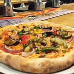 A thick crust pizza on a white plate.