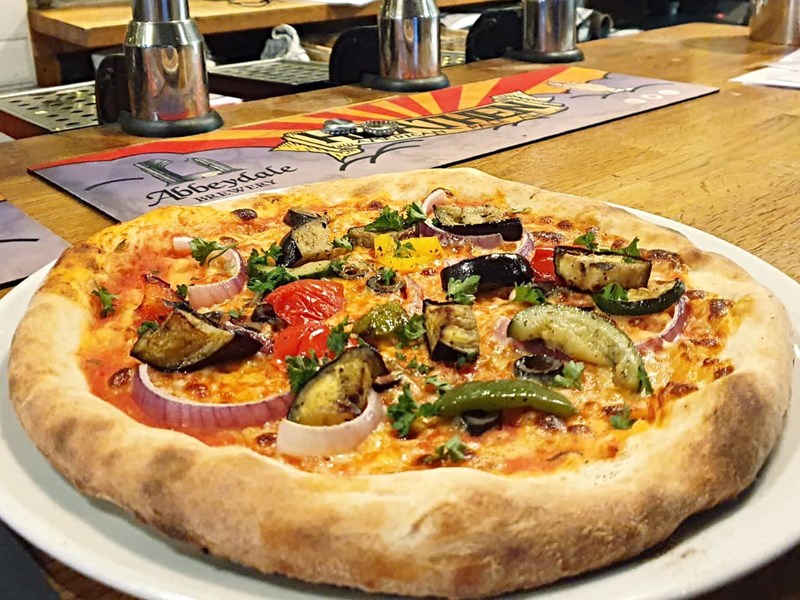 A thick crust pizza on a white plate.