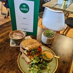 A tempting toasted sandwich on a table with a cappuccino