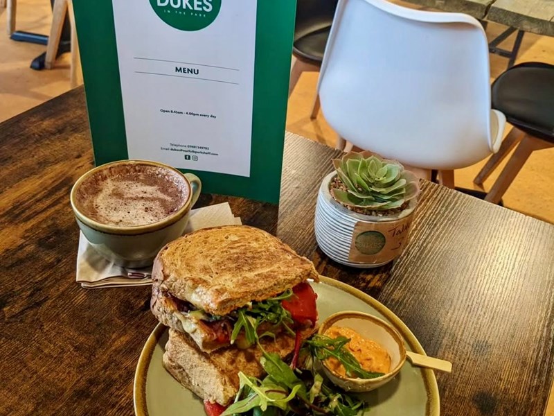 A tempting toasted sandwich on a table with a cappuccino