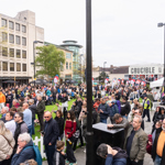 A large crowd and TV camera crew gathered in front of the Crucible Theatre during an outdoor snooker‑related event.