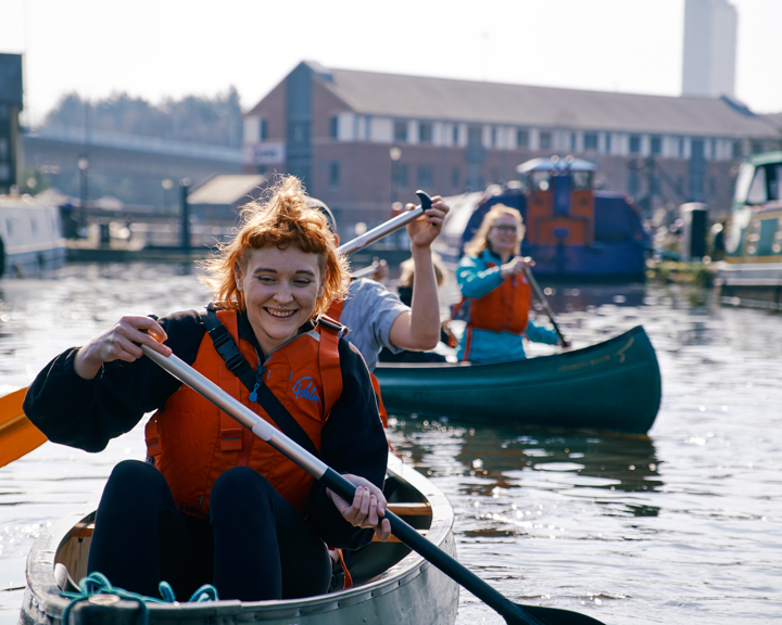 A group of people enjoying kayaking on the canal at Victoria Quays in Sheffield city centre. 
