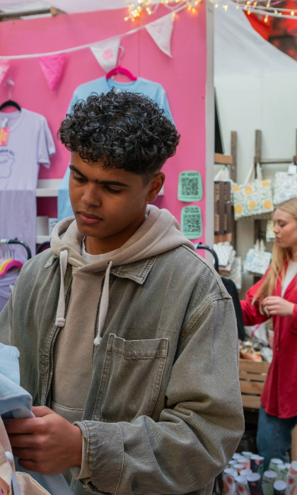 People looking at various stalls at an indoor market.