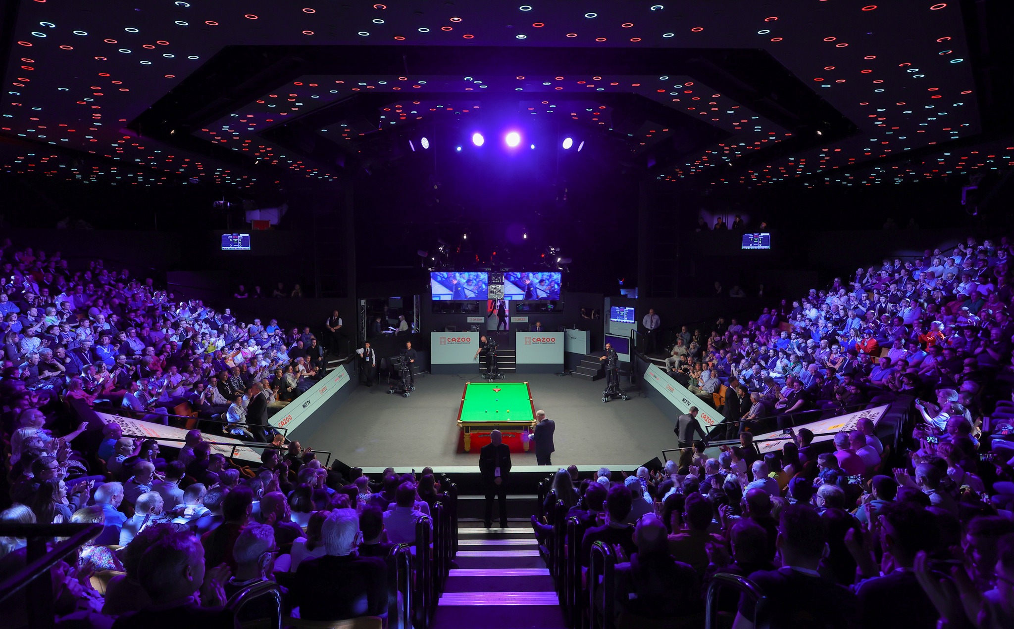 A snooker table set up at The Crucible. A capacity crowd waits for the match to start.