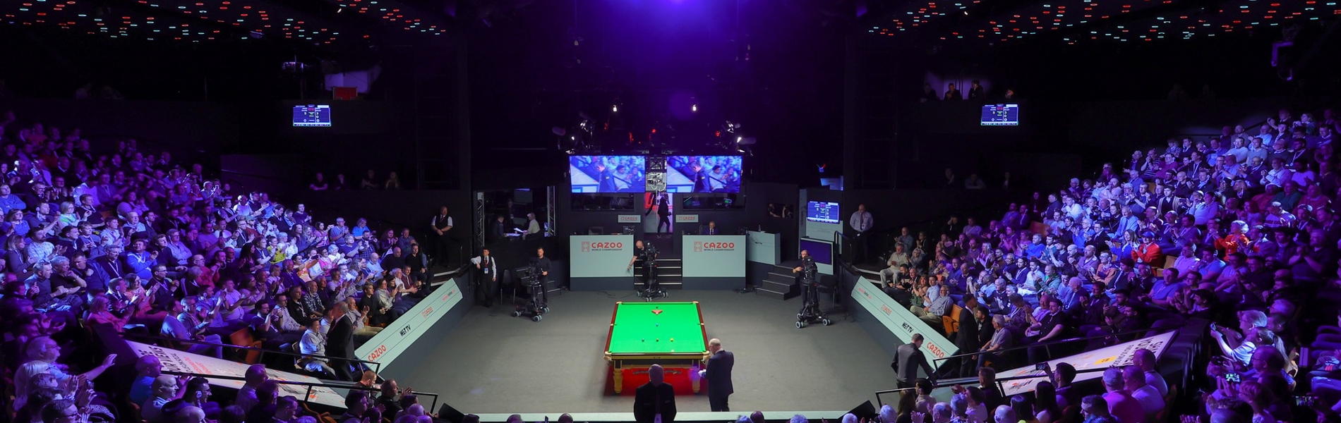 A snooker table set up at The Crucible. A capacity crowd waits for the match to start.