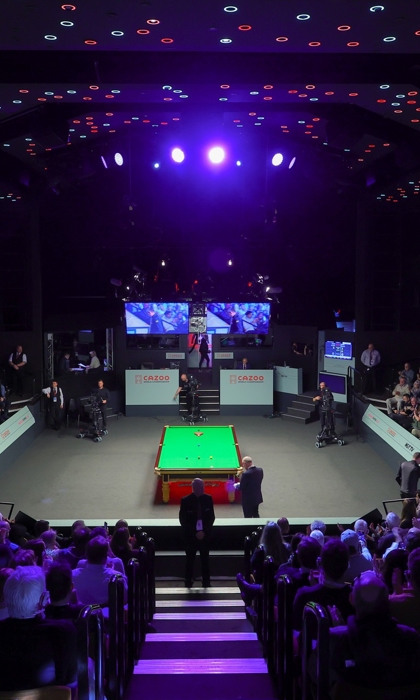 A snooker table set up at The Crucible. A capacity crowd waits for the match to start.