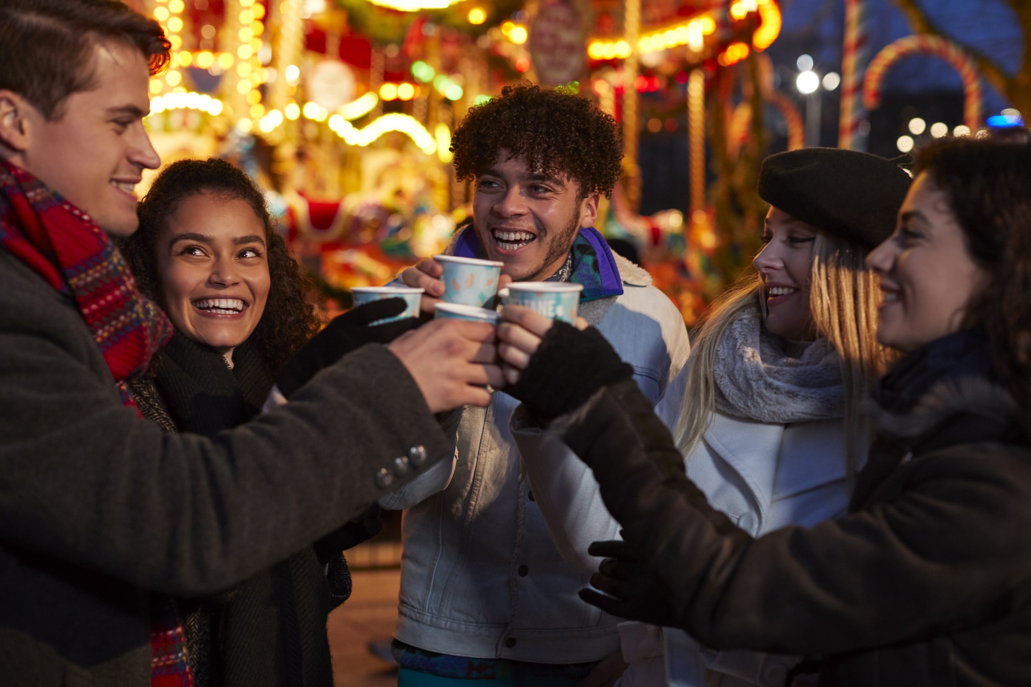 A group of friends cheers with mugs of mulled wine outside at Meadowhall's Magical Winterland 