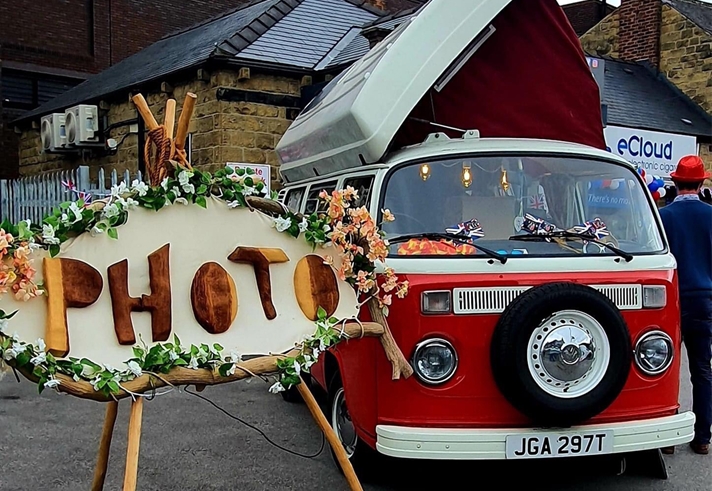 A vintage VW Camper Van set up for people to have their photos taken it.