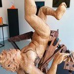 A sculpture of a human figure in wood at the Cupola Gallery.