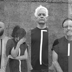 A black and white picture of the band. There are four pictures put next to each other, each picture consists of one member of the band