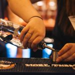 A cocktail being mixed on a bar.
