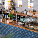 The blue-tilled counter at The Treehouse Cafe.  There are lots of drinks, and a display case filled with treats and pastries.