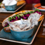 A close-up of several drinks and food dishes on a table.
