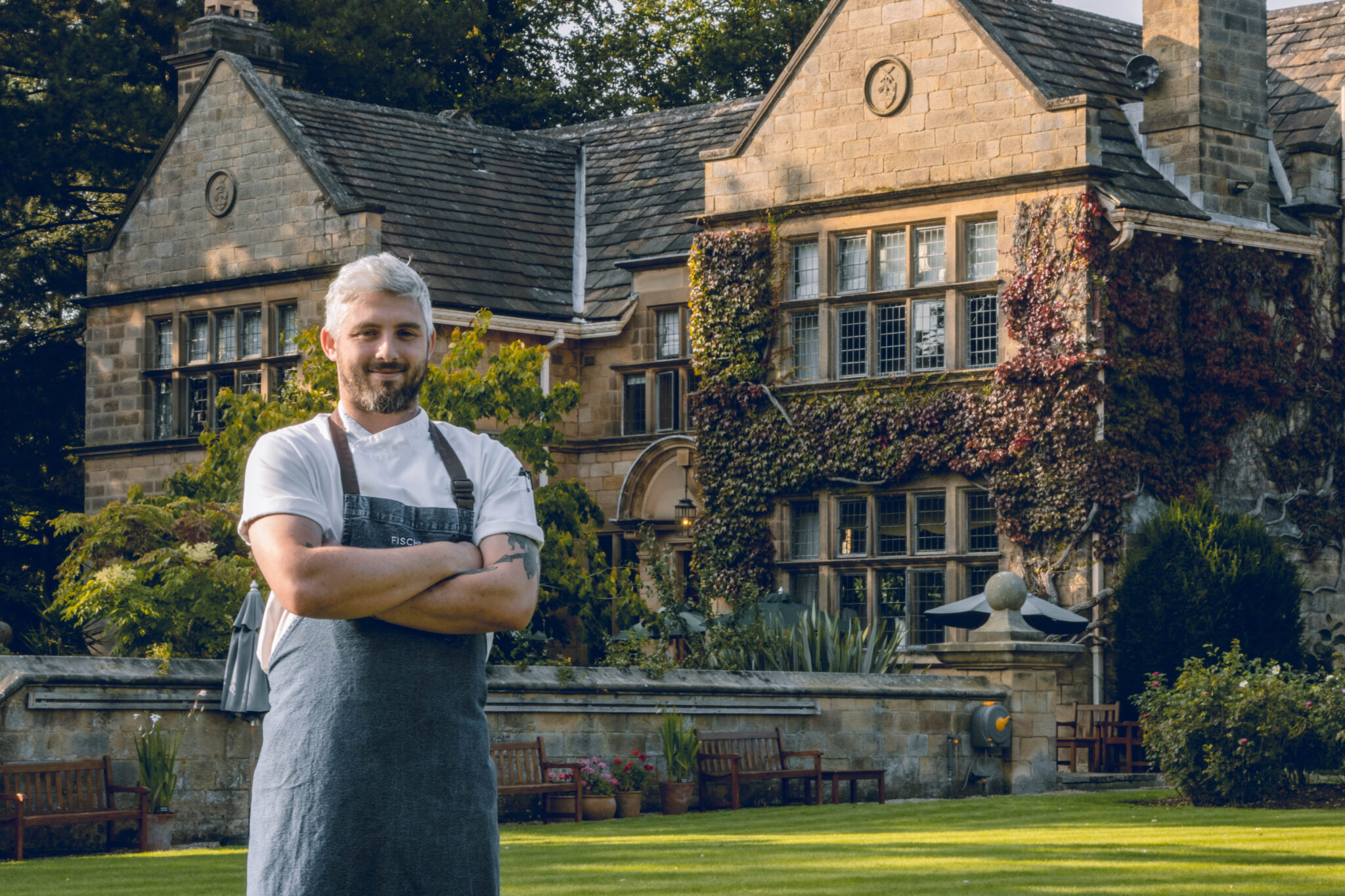 A chef standing outside Fischer’s Baslow Hall, an award-winning, stylish, boutique country house hotel and restaurant.