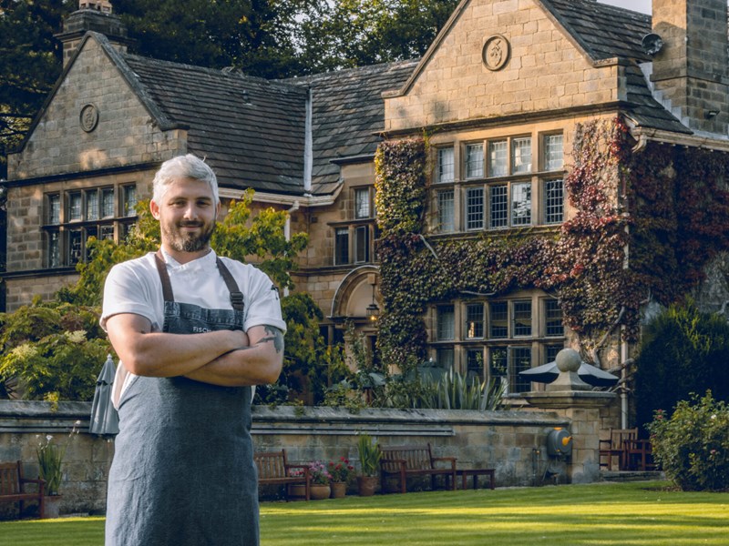 A chef standing outside Fischer’s Baslow Hall, an award-winning, stylish, boutique country house hotel and restaurant.