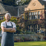 A chef standing outside Fischer’s Baslow Hall, an award-winning, stylish, boutique country house hotel and restaurant.