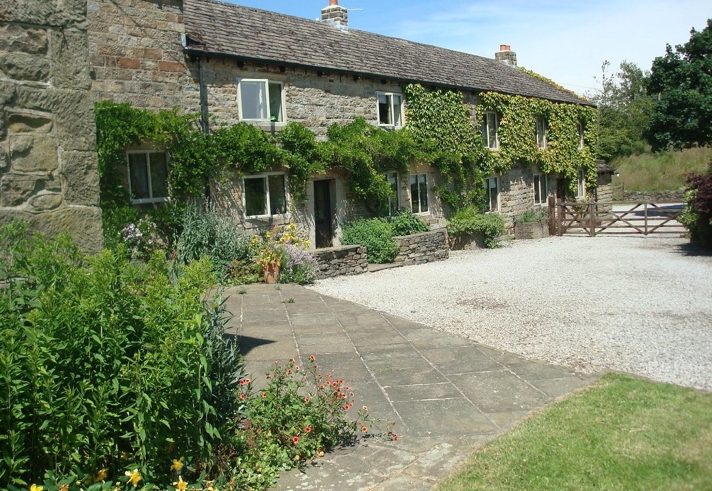Loadbrook Cottage – exterior view with green foliage draping across the front of the building.