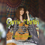 The artist Carrie Martin sat on cushions, holding her guitar.