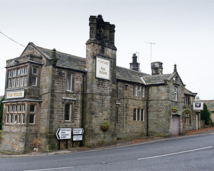 The exterior of The Fox House, a stone building with an impressive chimney stack.