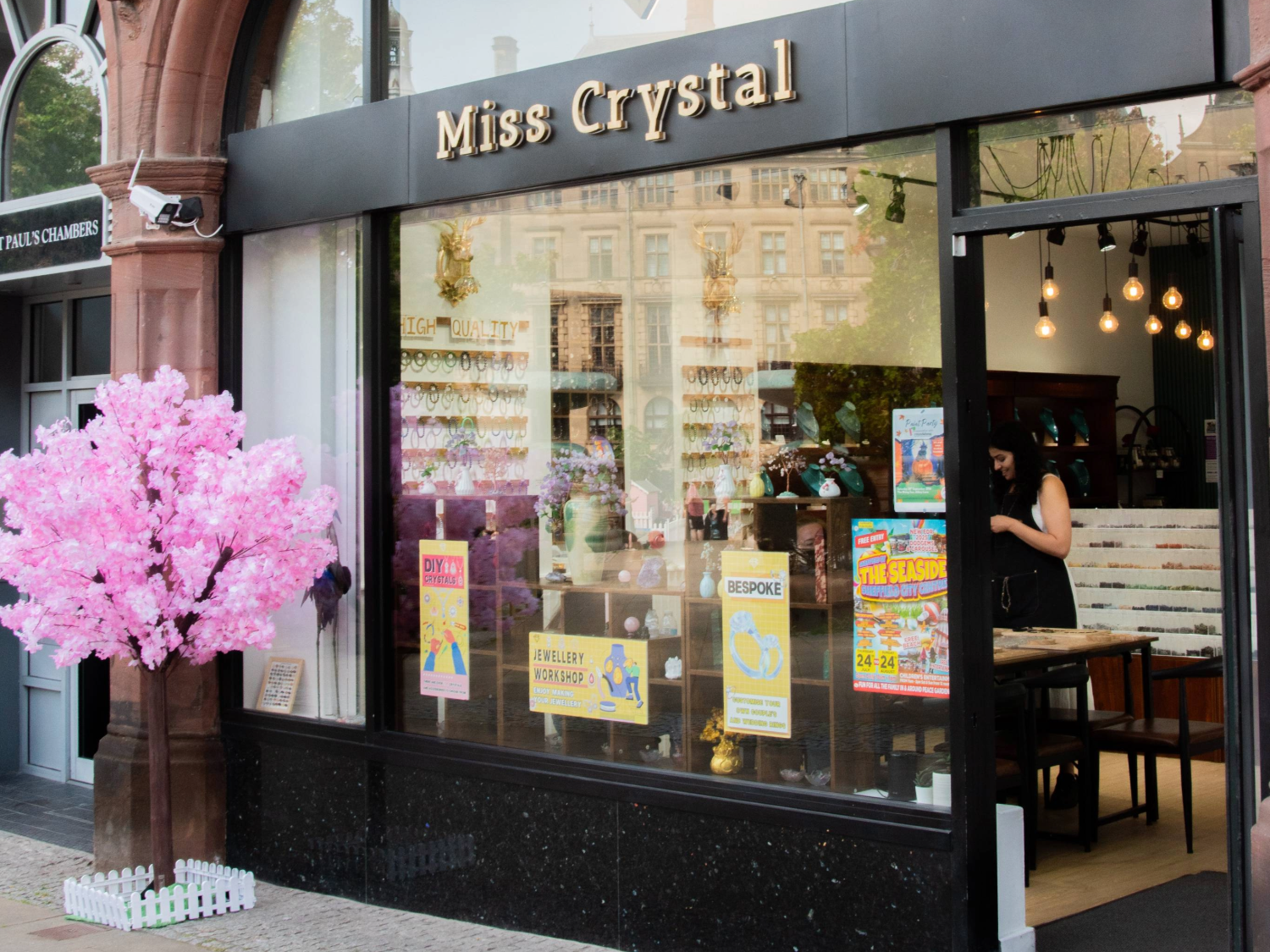 The entrance to Miss Crystal, with a small tree covered in pink blossom to one side.