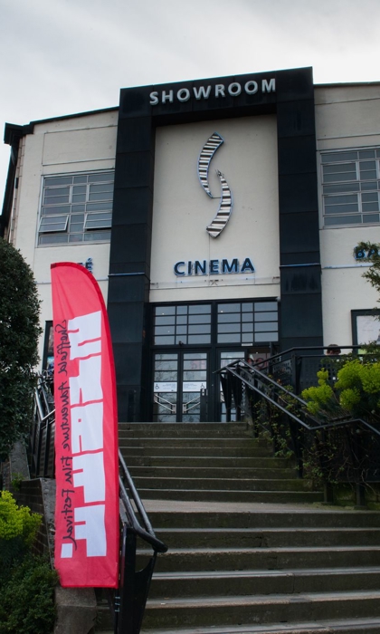 Showroom Cinema in front of grey skies, with a bright pink Sheffield Adventure Film Festival flag to the front left of the building