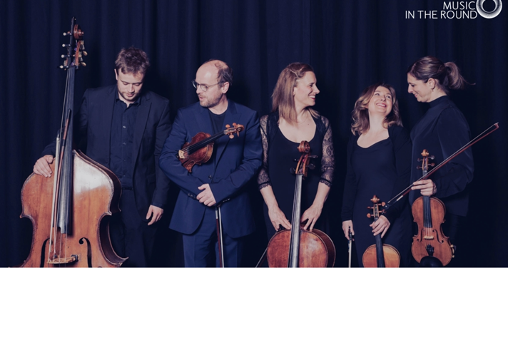 Members of Ensemble 360 in a relaxed photograph, holding their instruments and chatting and laughing.
