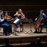 The Doric String Quartet on stage, performing.