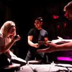 Three people trying to solve a clue in an escape room at The Great Escape Game.