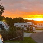 Sunset view over caravans at Waleswood Caravan and Camping Park with warm evening light