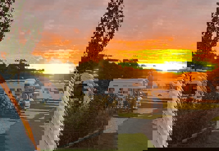 Sunset view over caravans at Waleswood Caravan and Camping Park with warm evening light