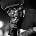 A black and white shot of a man singing into a microphone.