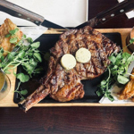 A steak on a platter with side dishes at Miller & Carter Steakhouse.