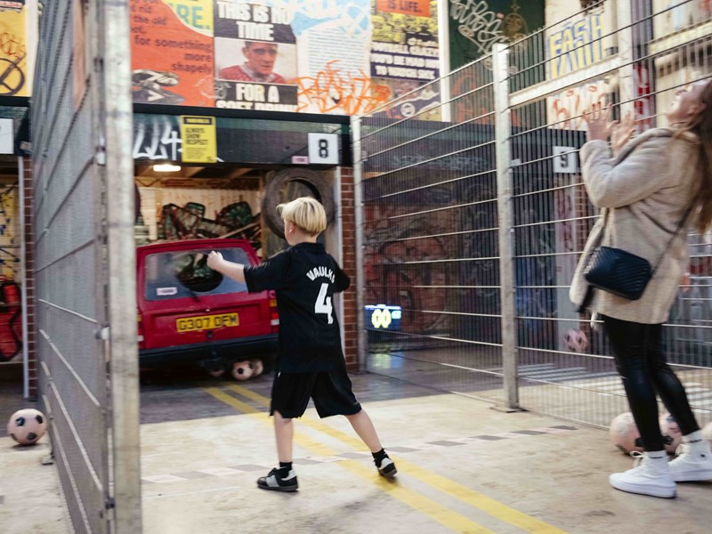 A woman and a boy playing football at Yard Ball.