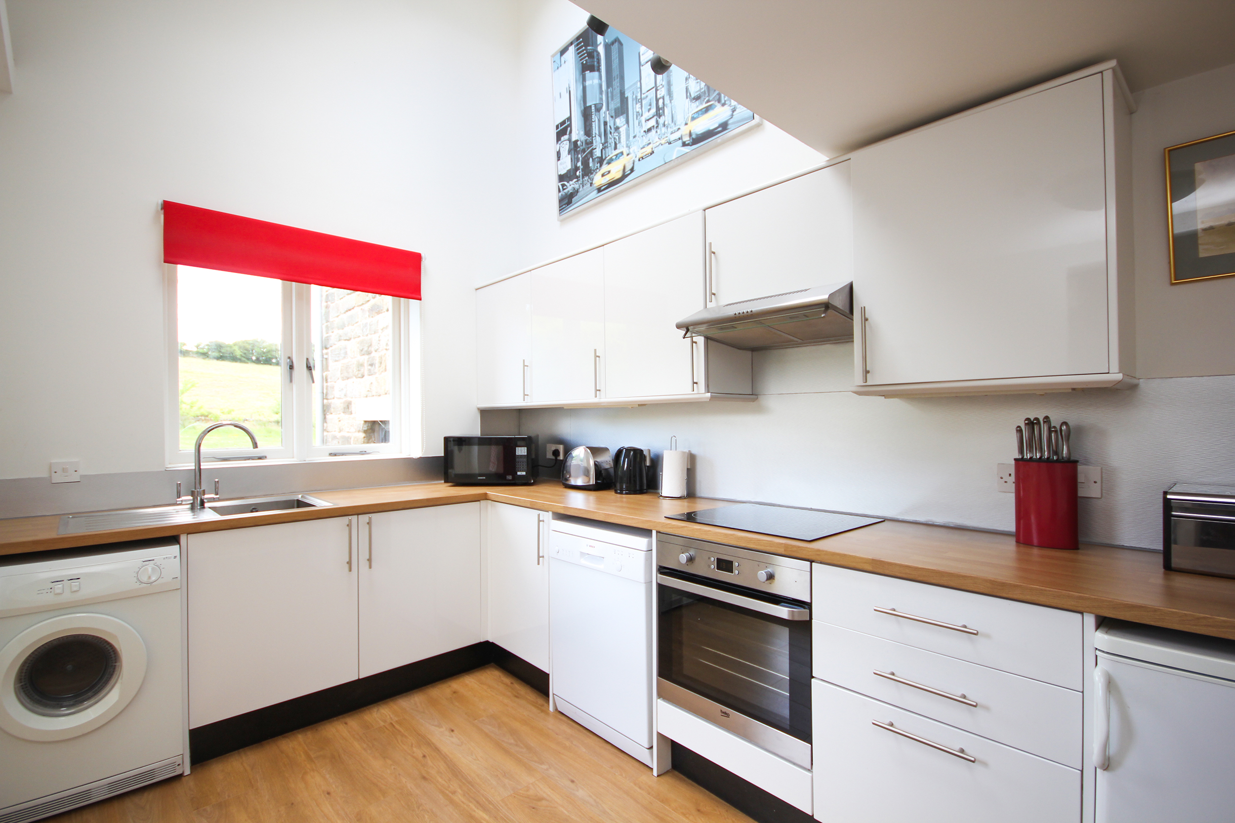 Interior view of a kitchen area with countertops, cabinets, sink, and appliances.