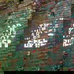 Southbank Warehouse stencilled on to a red brick wall that is partially covered in peeling green paint.