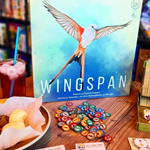 A table at The Dice Box Sheffield, with cakes and a drink and a game called Wingspan.