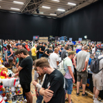 Crowds of people in a huge gall looking at trading stalls.