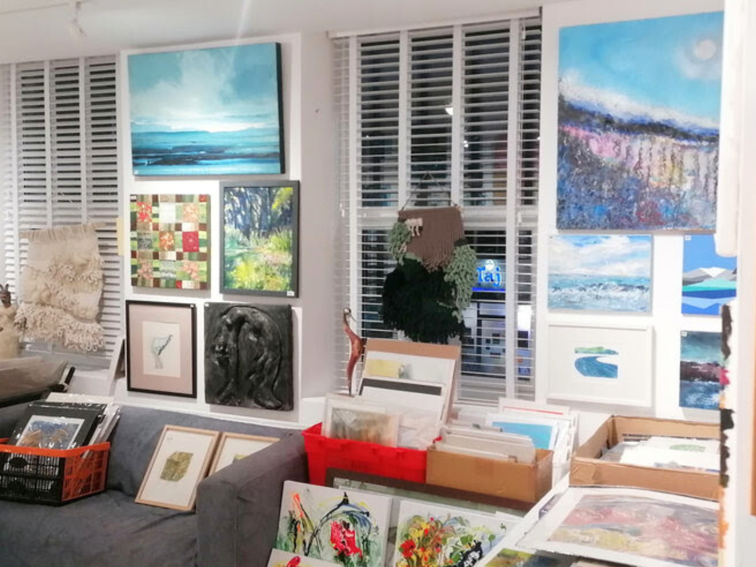 A gallery wall covered in paintings and artworks of all sizes.